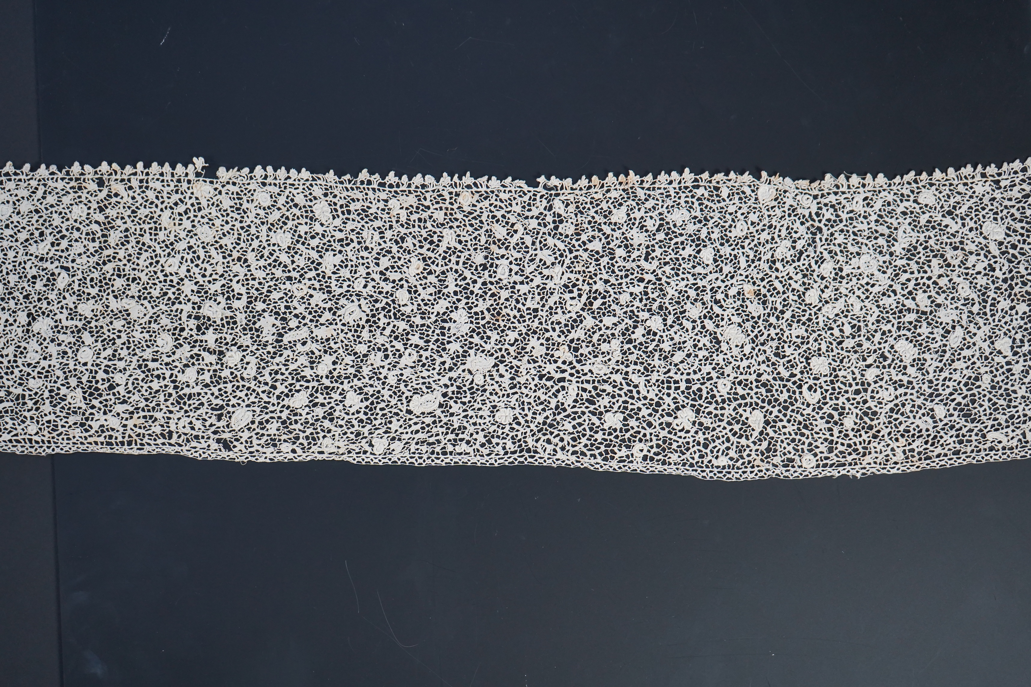 A late 17th century wide flounce of Point de France needle lace, together with a narrower flounce, both with raised elements of the design in the style of Point de Rose, but less so. This lace was very popular with the F